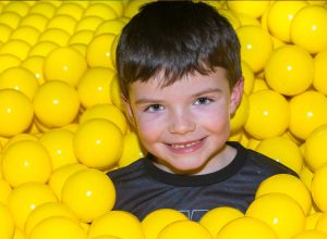 Little boy in a ball pond at Dino Soft Play