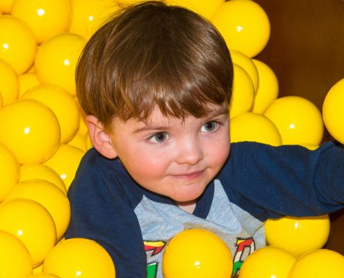 Toddler in ball pond at Dino Soft Play