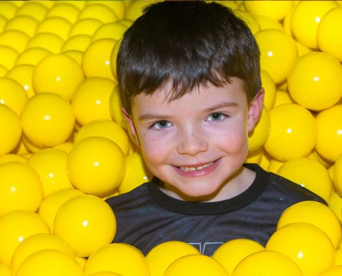 Little boy in a ball pond at Dino Soft Play